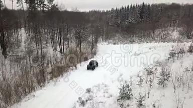 一辆6x6越野车的鸟瞰图，它在冬天森林里的雪覆盖的道路上行驶